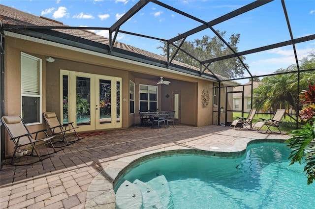 view of swimming pool featuring french doors, ceiling fan, glass enclosure, and a patio