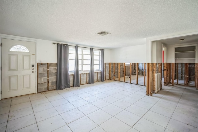 tiled foyer with a textured ceiling