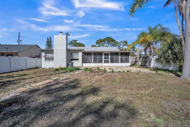 back of house featuring a yard and a sunroom