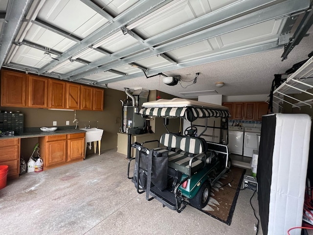 garage with a garage door opener, washer and clothes dryer, and sink