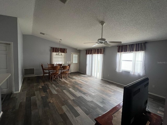 dining space with ceiling fan, lofted ceiling, a textured ceiling, and dark hardwood / wood-style flooring