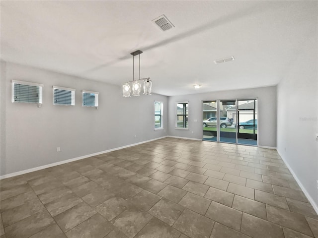 unfurnished room with a chandelier