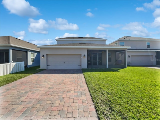 view of front facade with a garage, a front lawn, and a sunroom