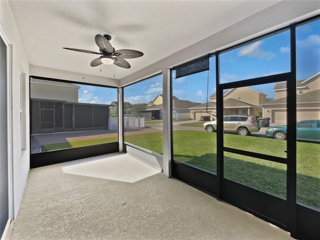 unfurnished sunroom featuring ceiling fan