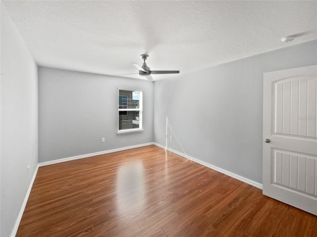 spare room featuring hardwood / wood-style flooring, ceiling fan, and a textured ceiling