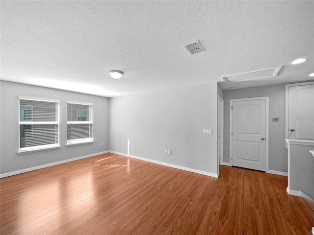 empty room featuring wood-type flooring and a textured ceiling