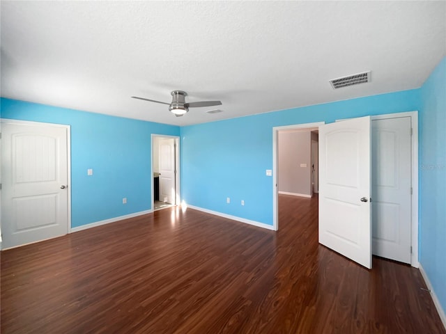 unfurnished bedroom featuring dark hardwood / wood-style flooring, a textured ceiling, and ceiling fan