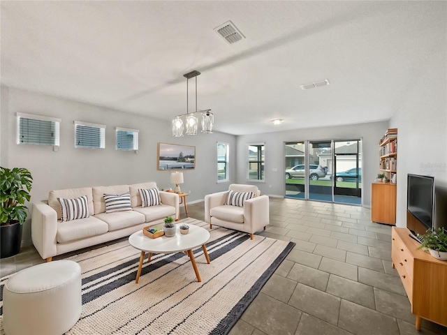 living room featuring an inviting chandelier and tile patterned floors