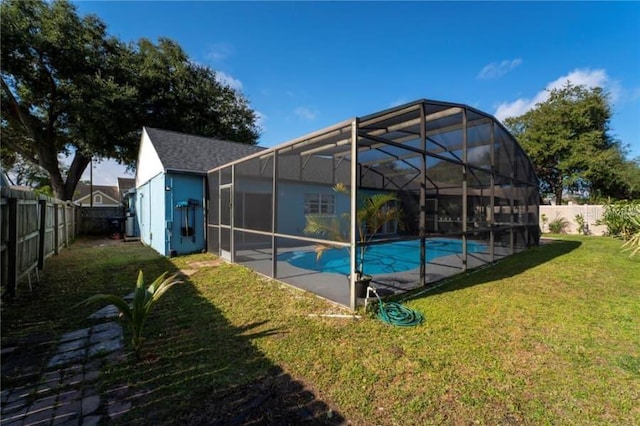 view of pool with a lawn and glass enclosure