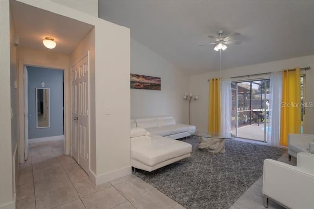 living room with ceiling fan, vaulted ceiling, and light tile patterned floors