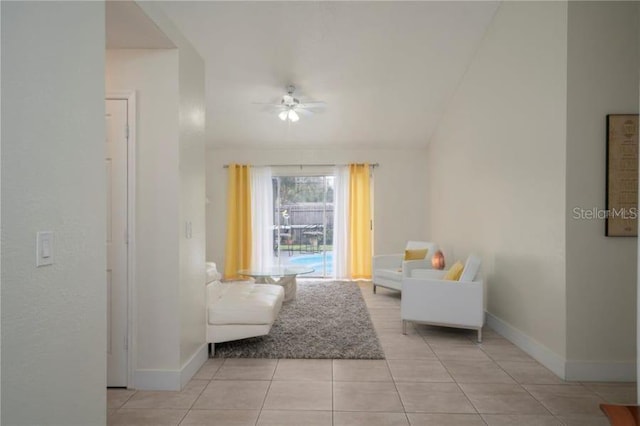 tiled living room with ceiling fan and vaulted ceiling