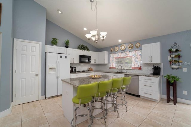 kitchen featuring white cabinetry, a kitchen island, white fridge with ice dispenser, and stainless steel dishwasher