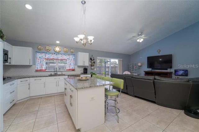 kitchen with sink, white cabinets, hanging light fixtures, a center island, and light tile patterned floors