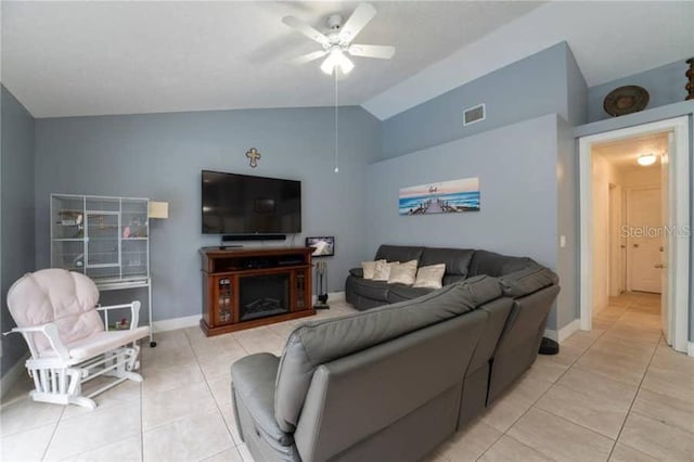 living room featuring ceiling fan, lofted ceiling, and light tile patterned floors