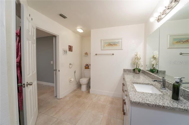 bathroom featuring vanity, tile patterned flooring, and toilet