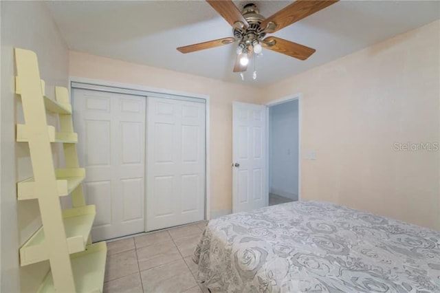 bedroom featuring light tile patterned flooring, ceiling fan, and a closet