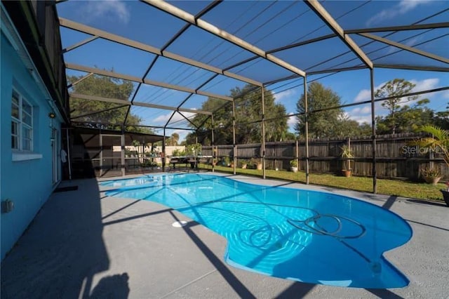 view of pool with a patio area and glass enclosure