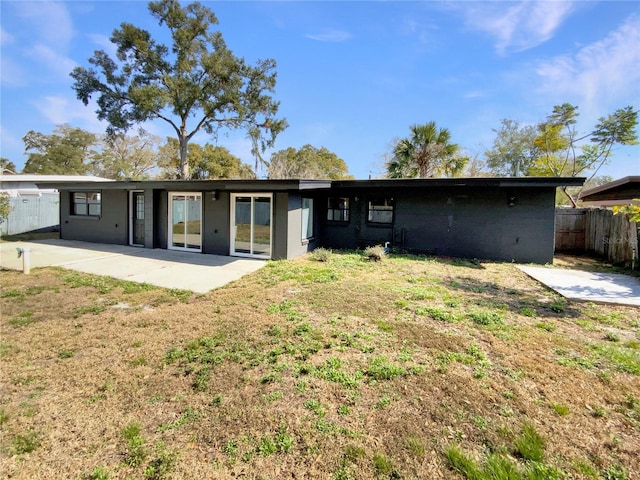 back of property featuring a patio area and a lawn
