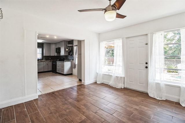 kitchen with tasteful backsplash, light hardwood / wood-style flooring, gray cabinetry, and ceiling fan