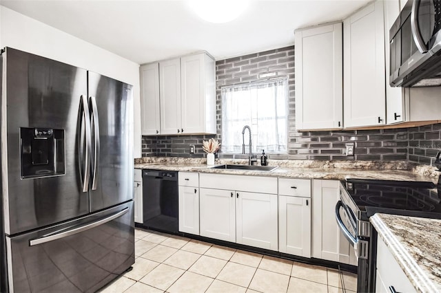 kitchen featuring white cabinetry, appliances with stainless steel finishes, light stone countertops, and sink