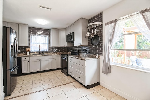 kitchen with light tile patterned floors, gray cabinets, backsplash, electric range, and stainless steel fridge with ice dispenser