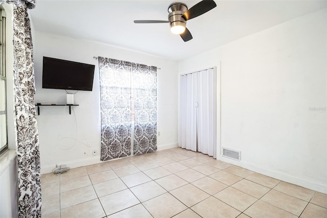 unfurnished bedroom with light tile patterned floors and ceiling fan