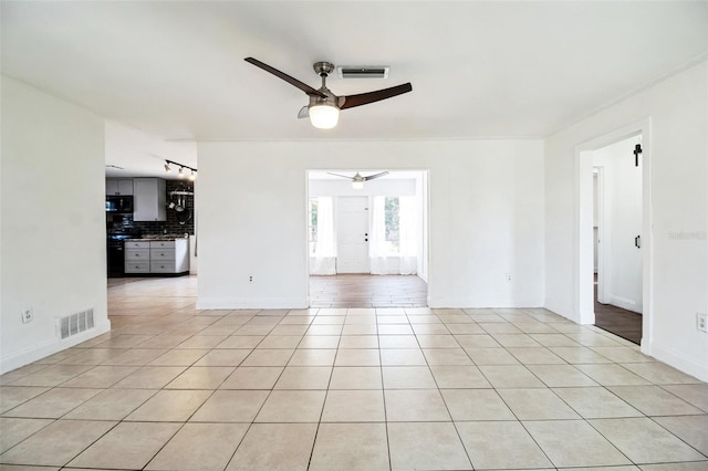 unfurnished living room with ceiling fan and light tile patterned floors