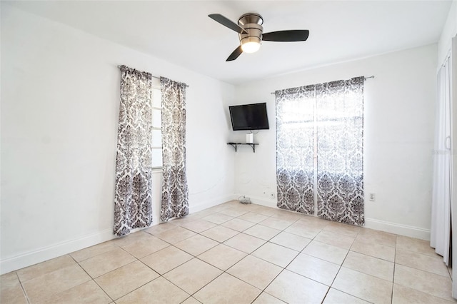 tiled spare room with ceiling fan