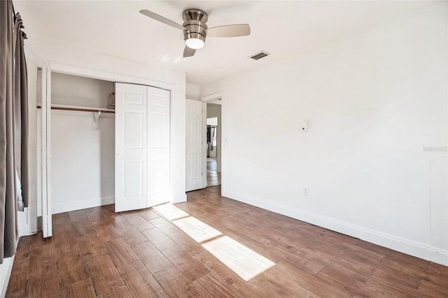 unfurnished bedroom with ceiling fan, dark hardwood / wood-style flooring, and a closet