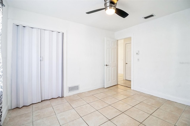 tiled spare room featuring ceiling fan