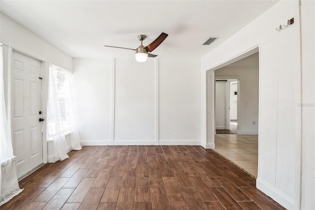 spare room with dark wood-type flooring and ceiling fan