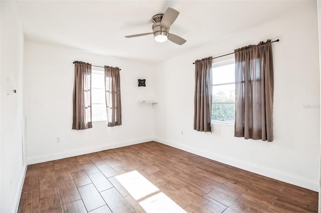 spare room with hardwood / wood-style floors, a wealth of natural light, and ceiling fan