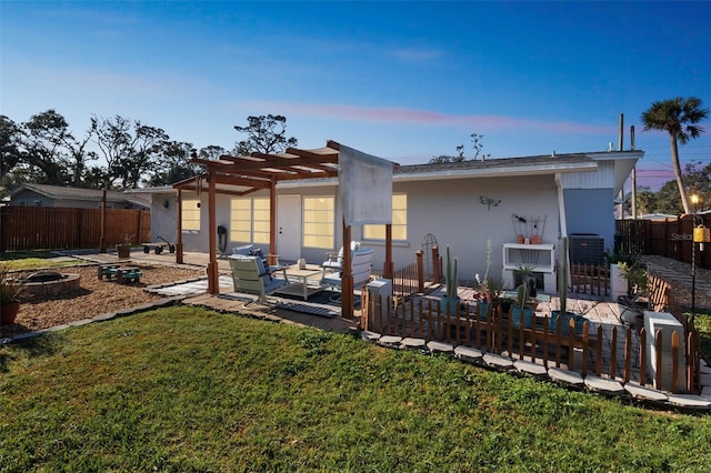 back house at dusk with a patio area, an outdoor hangout area, a yard, and a pergola