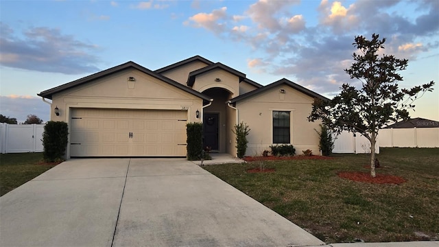 ranch-style house featuring a garage and a lawn