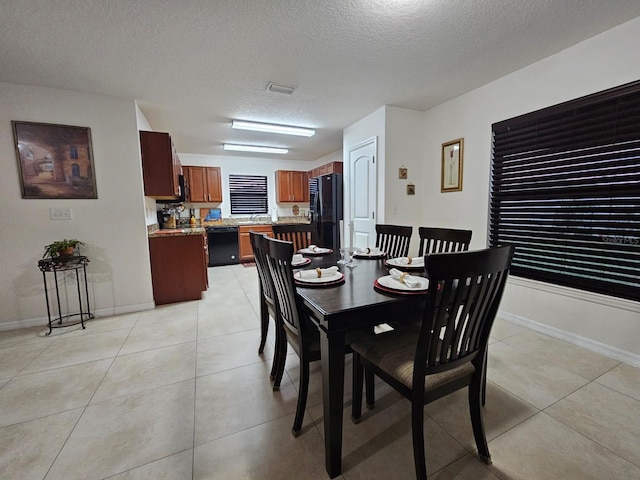 tiled dining space featuring a textured ceiling