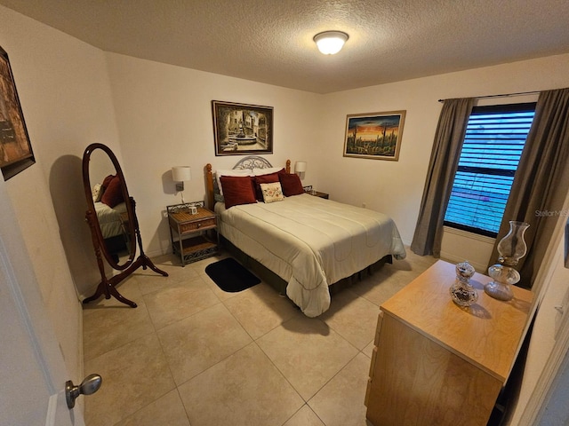 bedroom with light tile patterned floors and a textured ceiling