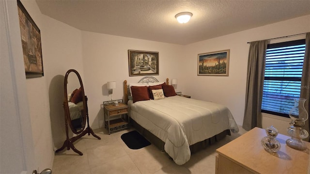 bedroom featuring light tile patterned flooring and a textured ceiling