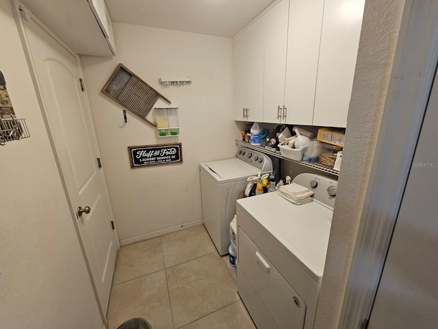 laundry room with cabinets, light tile patterned floors, and independent washer and dryer