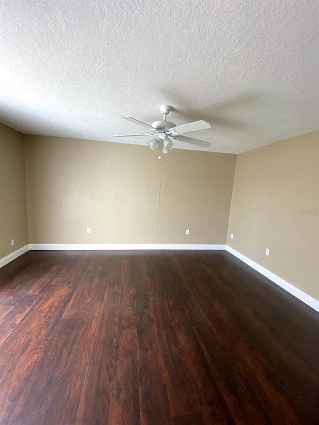 spare room featuring ceiling fan, dark wood-type flooring, a textured ceiling, and baseboards