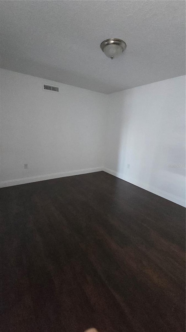 516 Orange Dr Unit 17, Altamonte Springs, FL 32701 - unfurnished room with baseboards, a textured ceiling, visible vents, and dark wood-type flooring