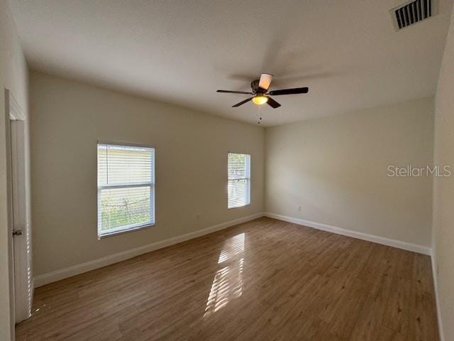 spare room featuring ceiling fan and dark hardwood / wood-style floors