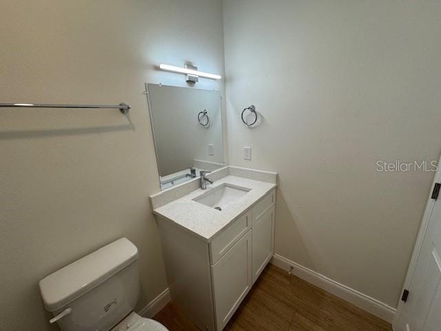 bathroom featuring vanity, hardwood / wood-style floors, and toilet