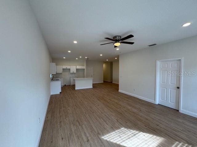 unfurnished living room with ceiling fan and dark hardwood / wood-style flooring