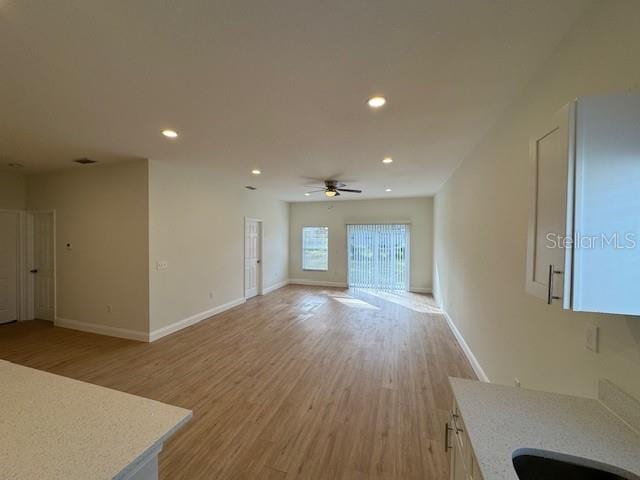 unfurnished living room with ceiling fan and light hardwood / wood-style floors