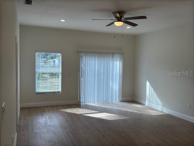 spare room featuring wood-type flooring and ceiling fan