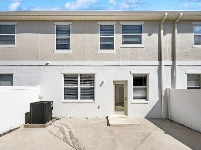 rear view of property featuring a patio and cooling unit