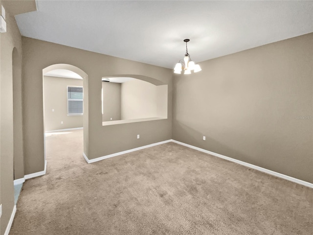 unfurnished room featuring an inviting chandelier and carpet