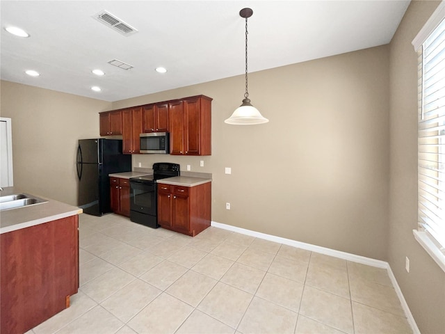 kitchen with pendant lighting, sink, light tile patterned floors, and black appliances
