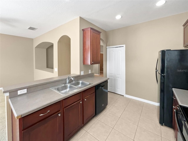 kitchen with light tile patterned flooring, sink, a textured ceiling, and black appliances