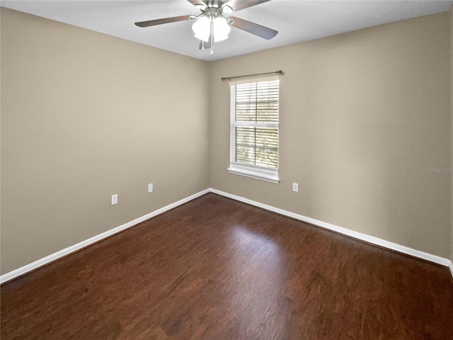spare room with dark hardwood / wood-style flooring and ceiling fan